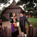 Beeksheepers in costume by half timbered farmhouse